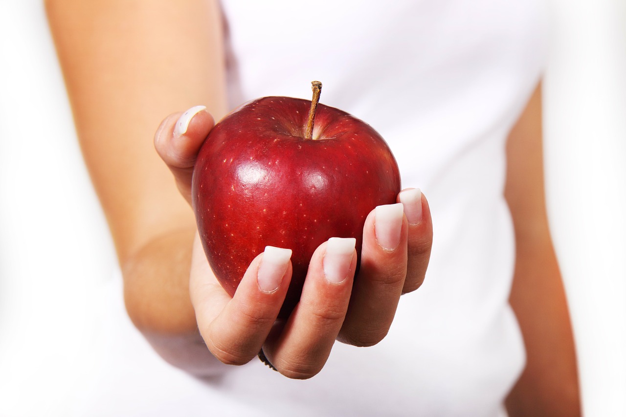 Lady holding an apple - Tips for eating and drinking well