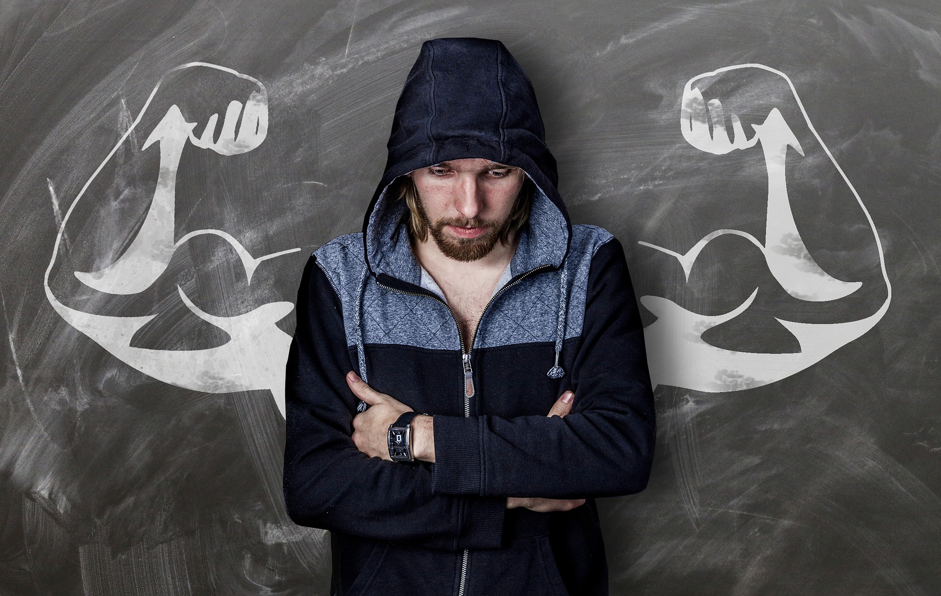 weak man standing in front of chalk board with strong arms on it - body guides