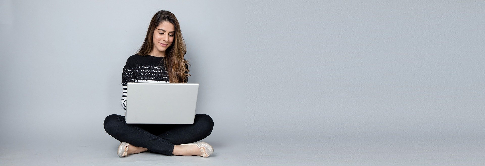 lady sitting cross legged with a laptop