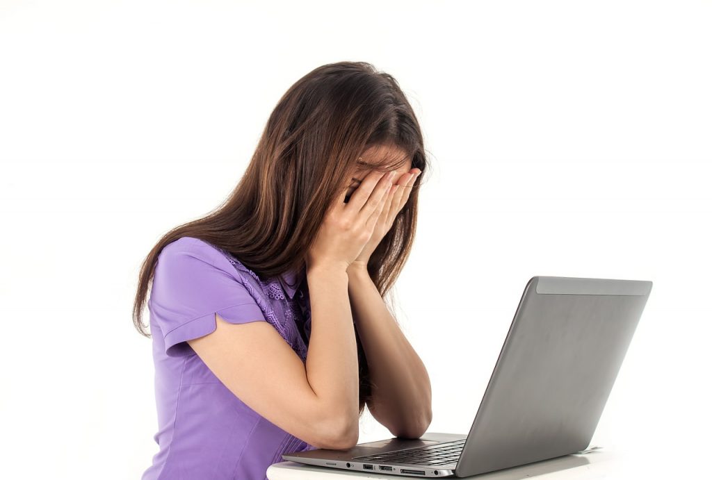 woman looking stressed in front of a laptop