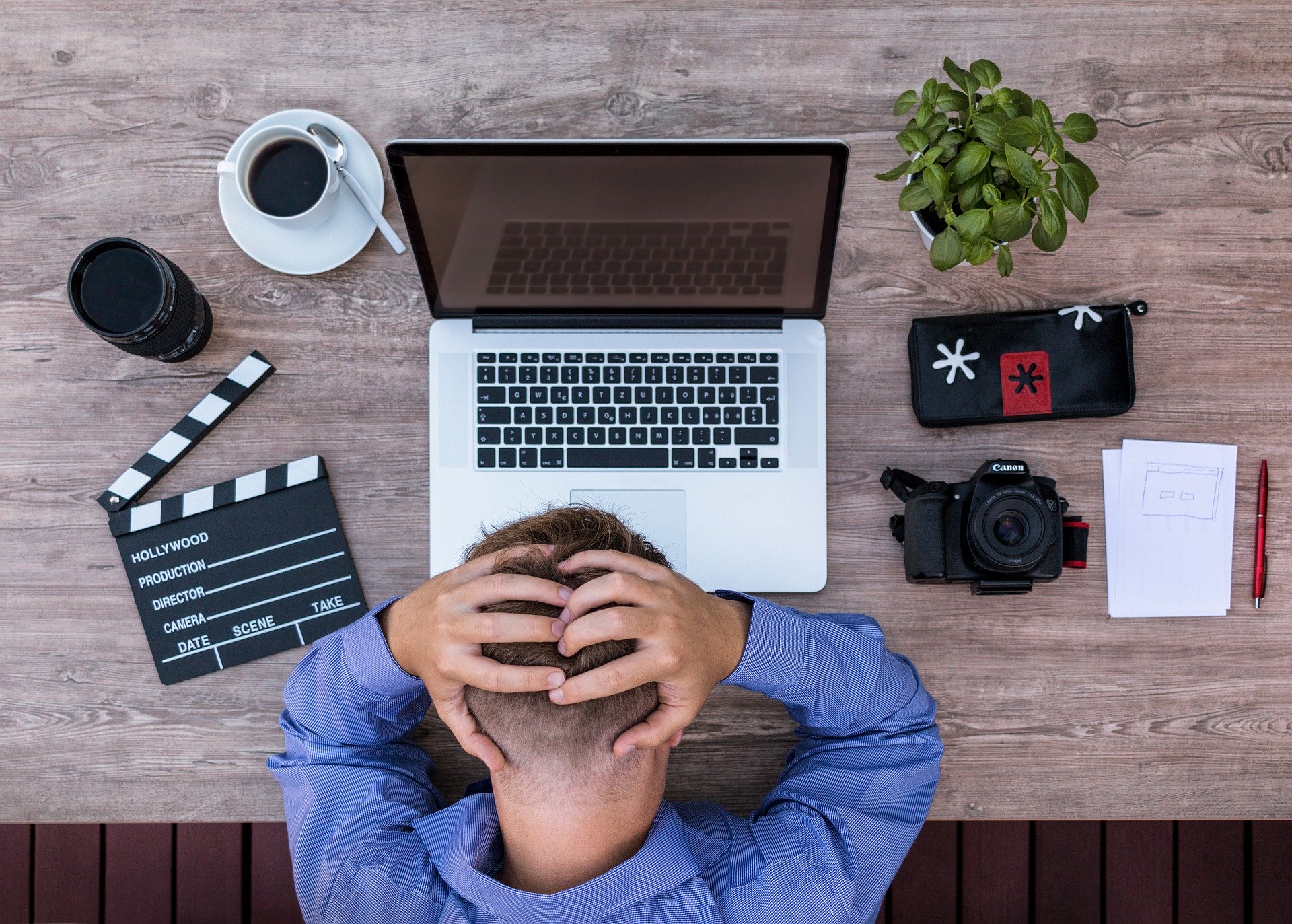 man looking frustrated next to a laptop