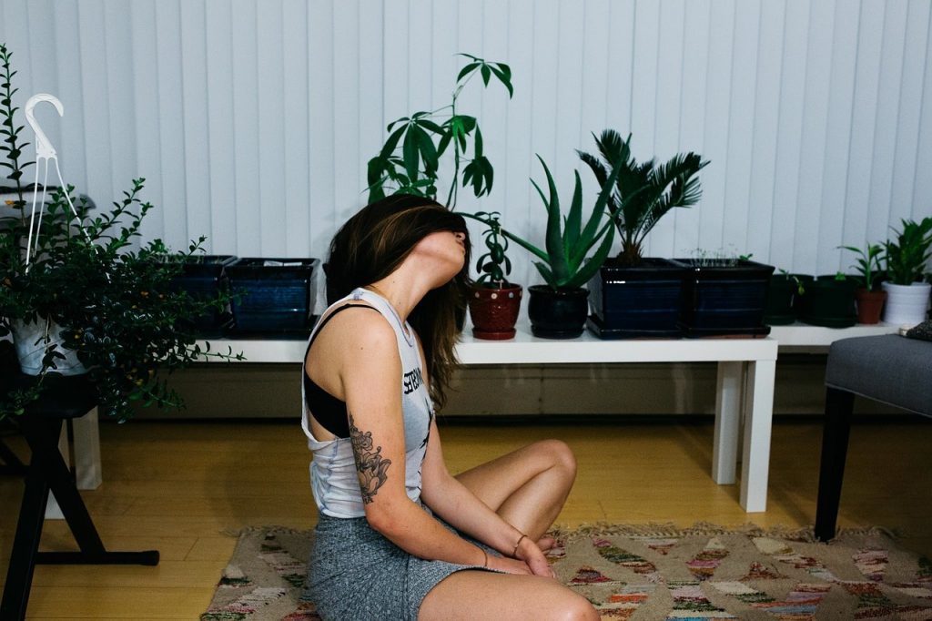 Girl sat meditating practicing to maintain mental wellbeing while working from home