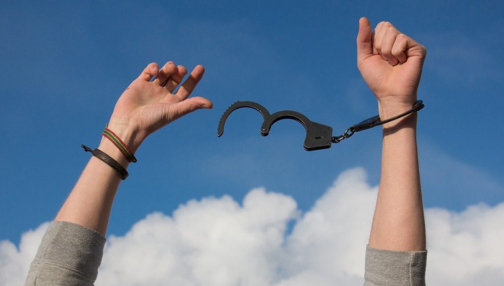 Person holding their hands up with undone handcuffs