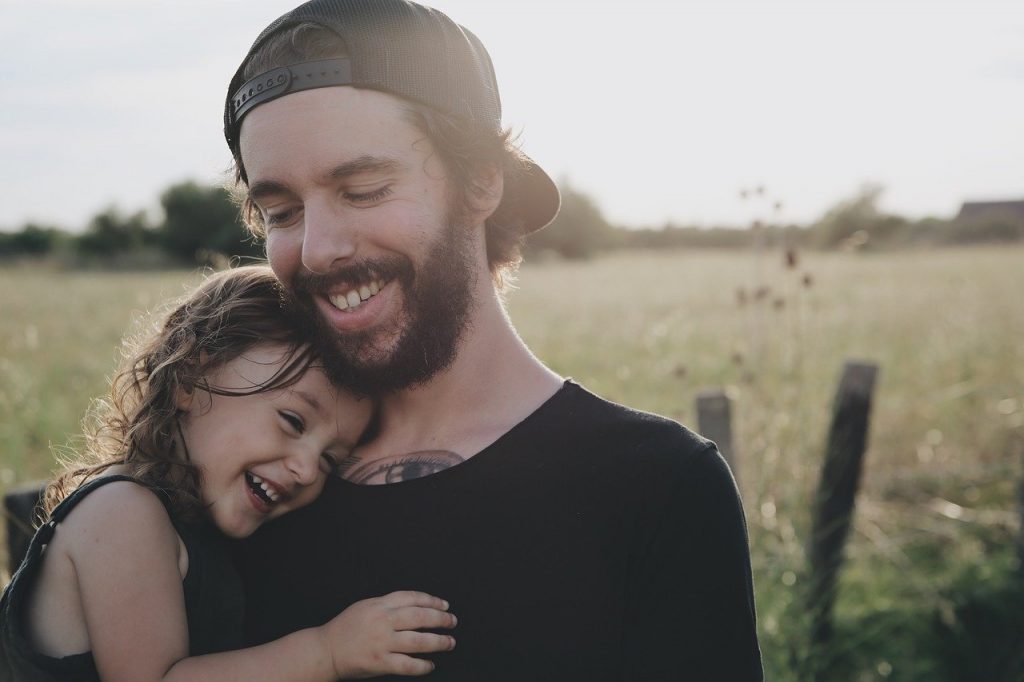 man smiling holding child