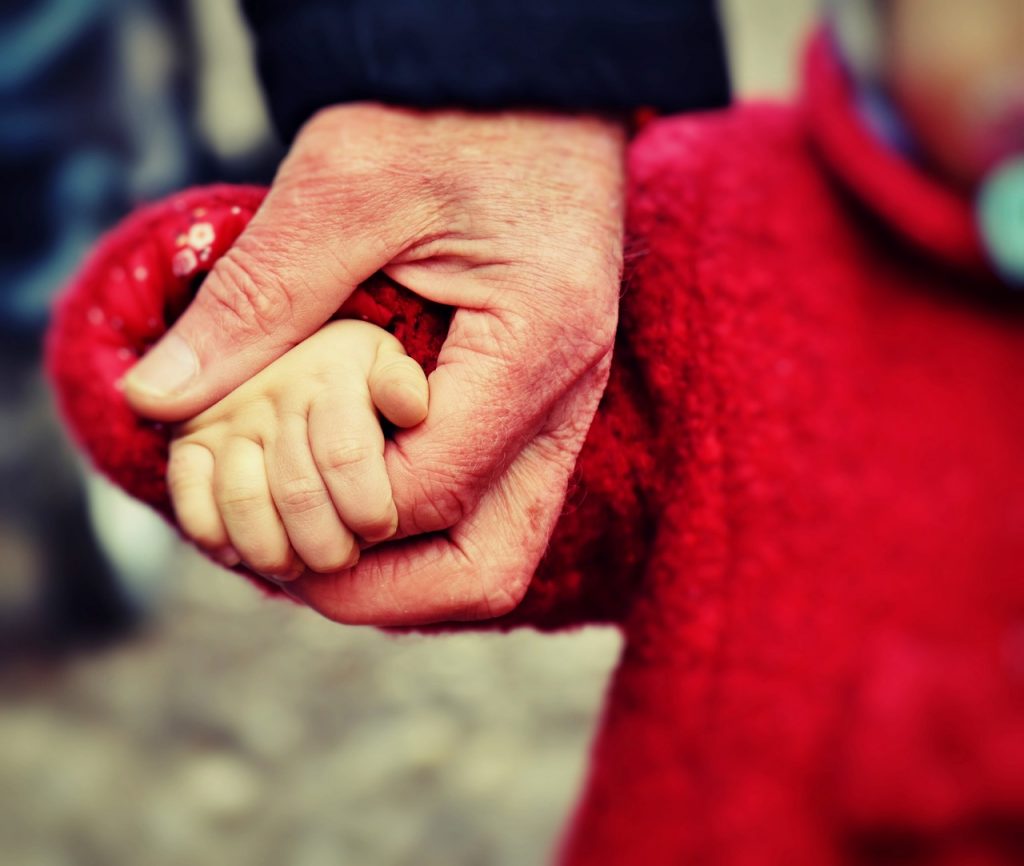 Family member holding hands with a small child