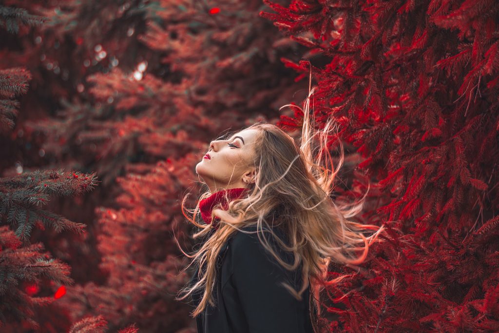 Woman looking refreshed in a forest after practicing forest bathing