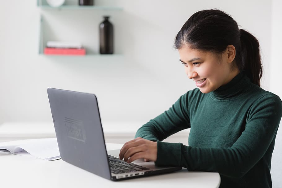 woman looking happy at laptop not hating Monday