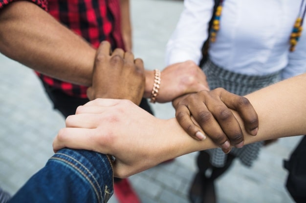 People with hands stacked treating other with respect