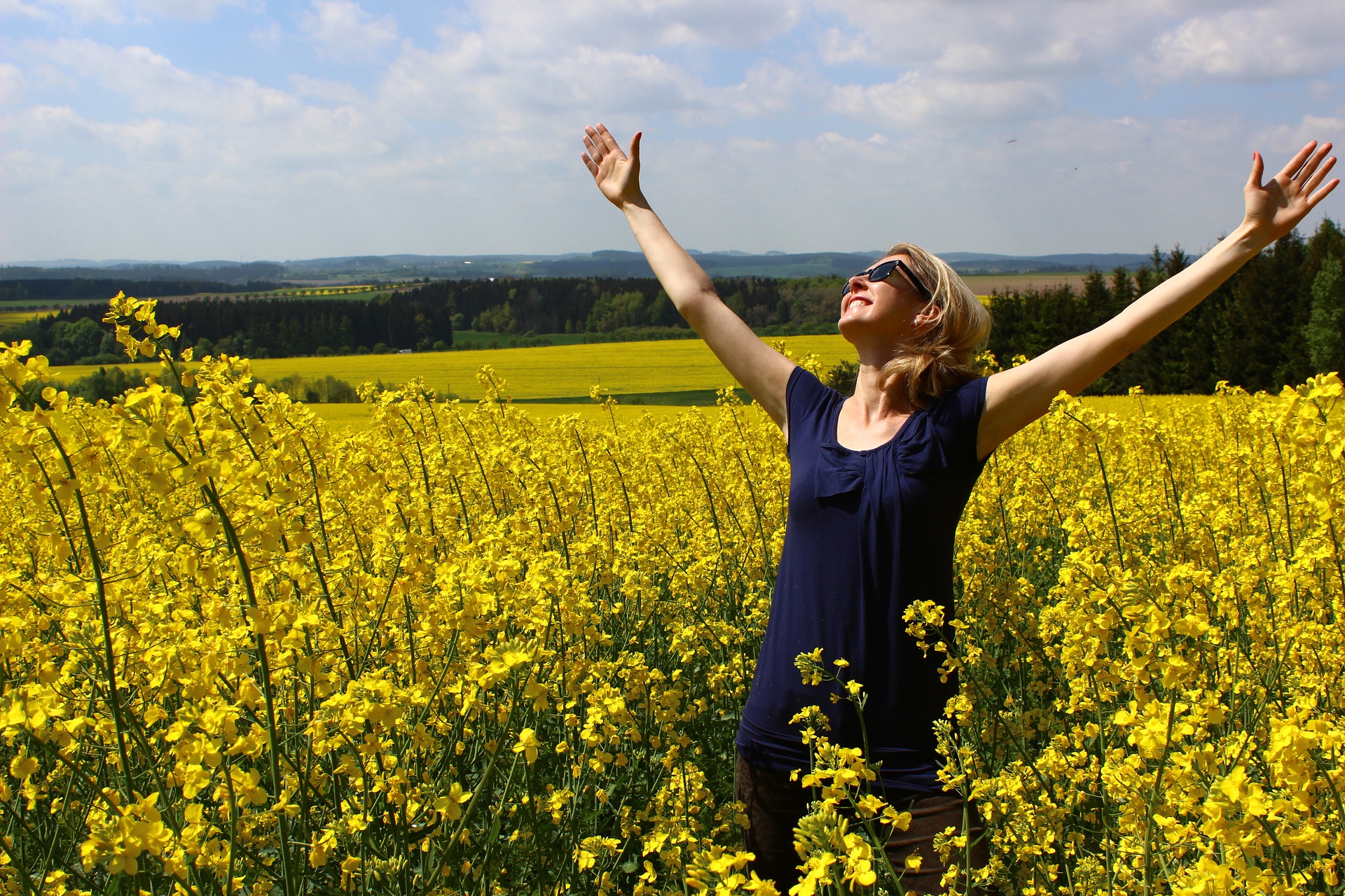 Woman standing in field looking grateful - How to practice gratitude