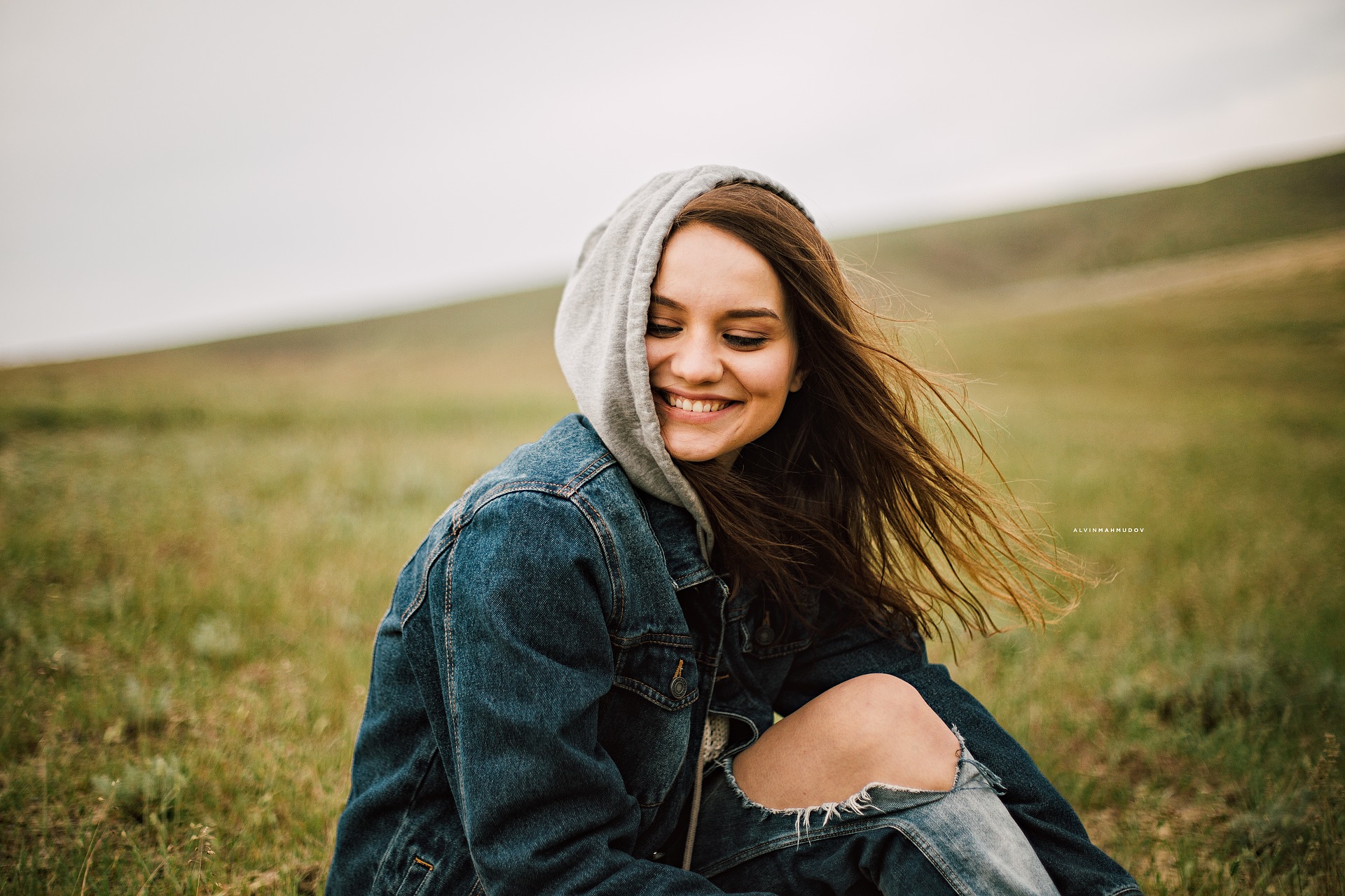 woman sitting on her own smiling - How to be happy as an introvert