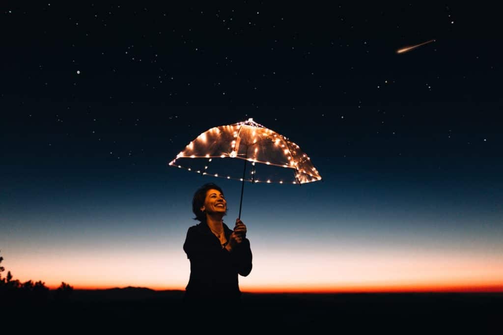 woman with an umbrella with fairy lights - 101 Ways to be happy