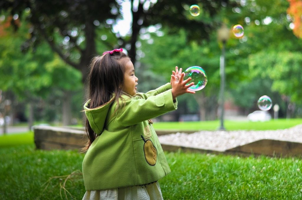 Little girl playing with a bubble - Be happy basics