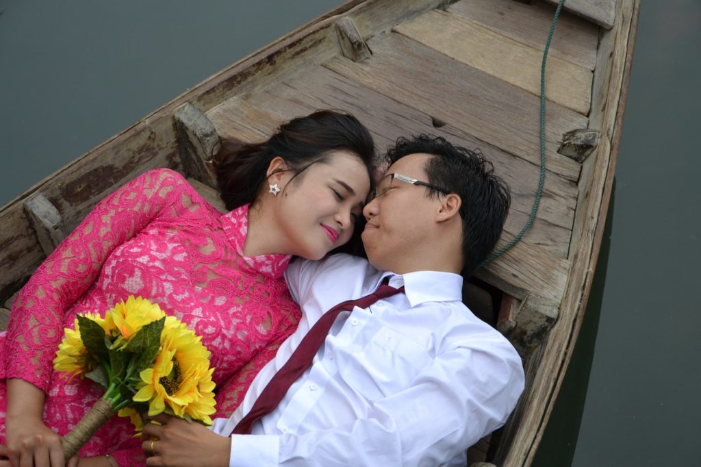 couple lying on a boat - ways to be romantic