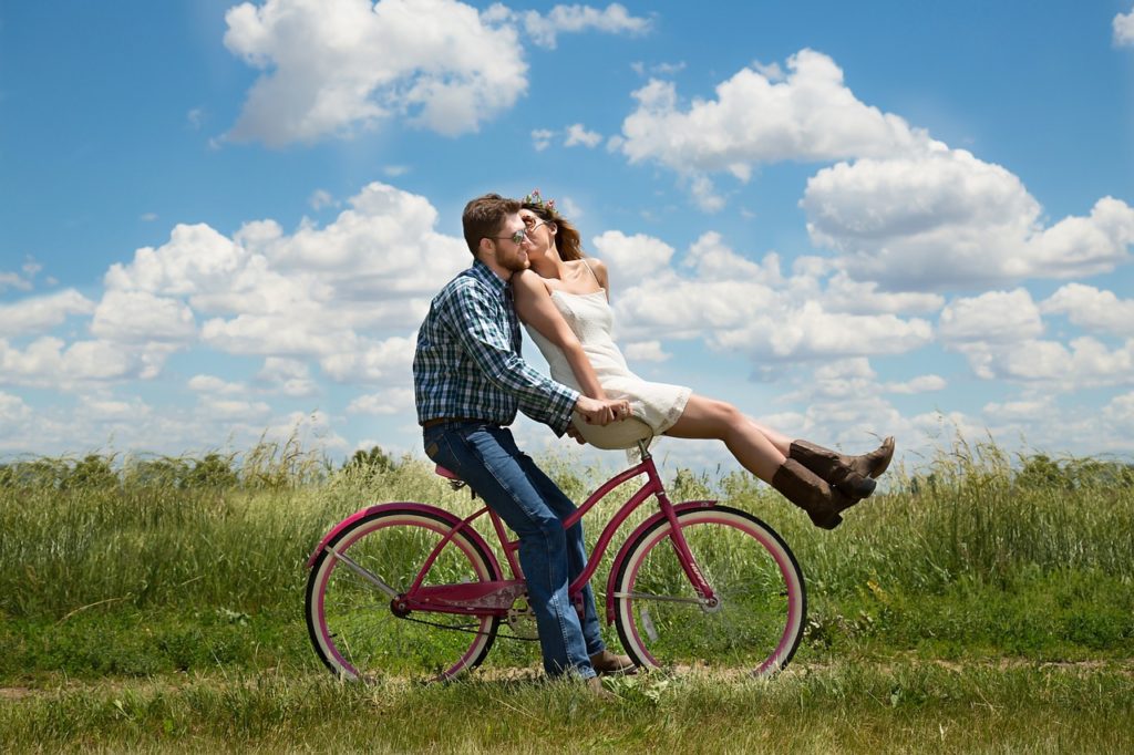 couple having a romantic bike ride - what is romance