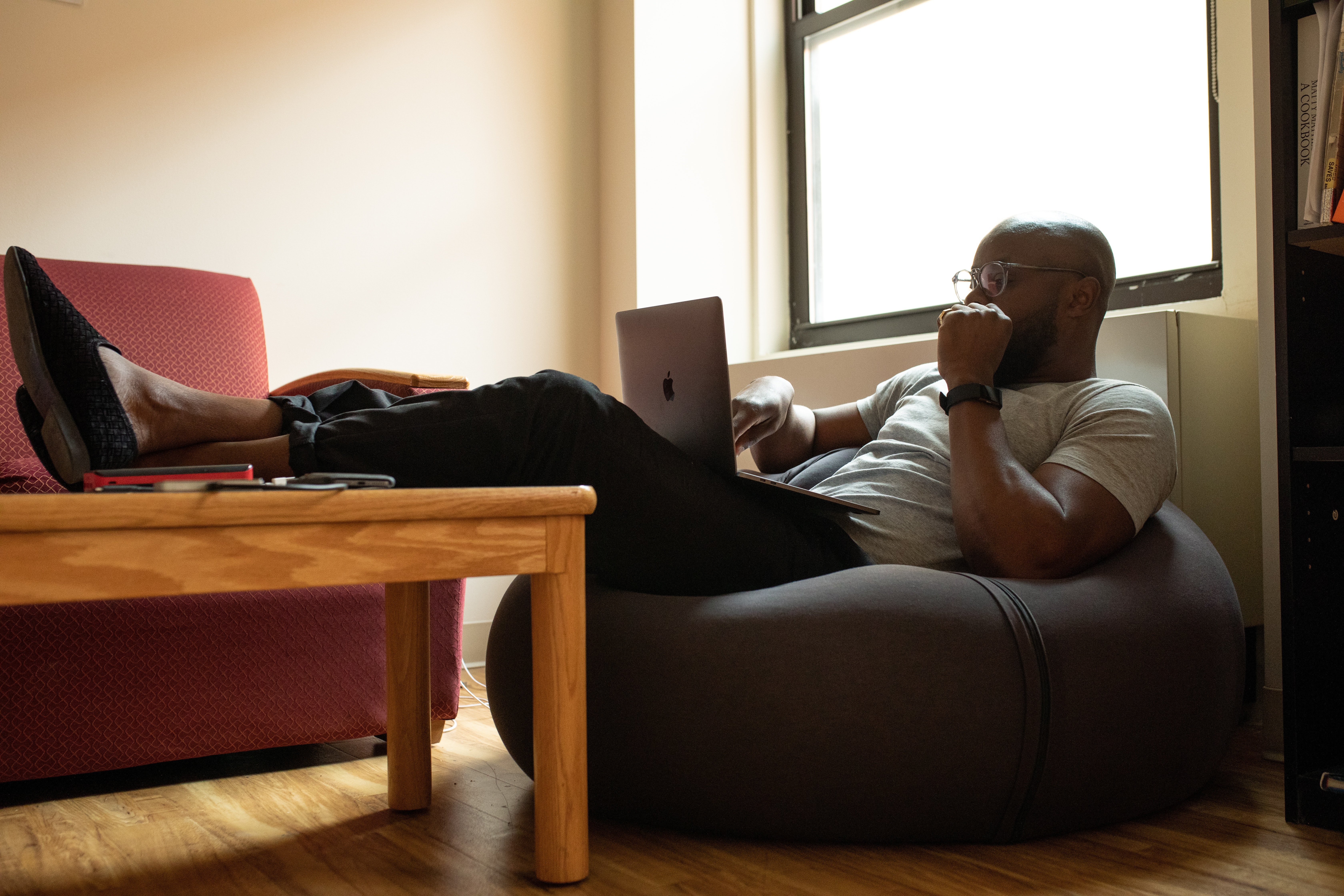 man sitting on bean bag caring less about work - How to care less about work