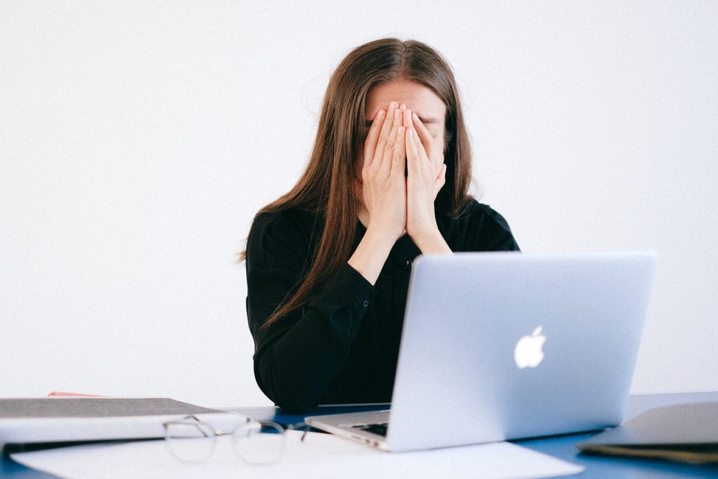 woman looking worried at work - Reasons to care less about work - How to care less about work