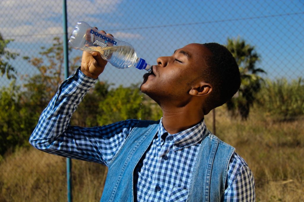 man drinking a bottle of water - Easy ways to drink more water - how to drink more water