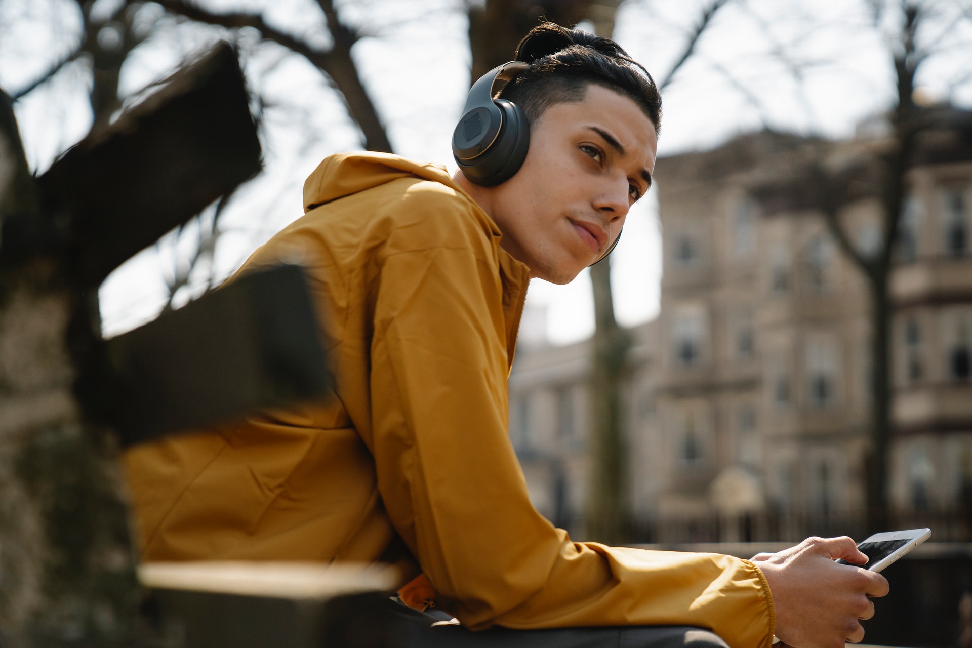 man sat on a bench listening to a mental wellbeing - mental wellbeing podcasts