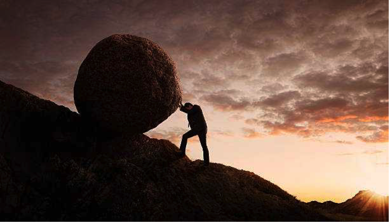 Person pushing a boulder up a hill - Why You Should Never Give Up In Life (No Matter What)