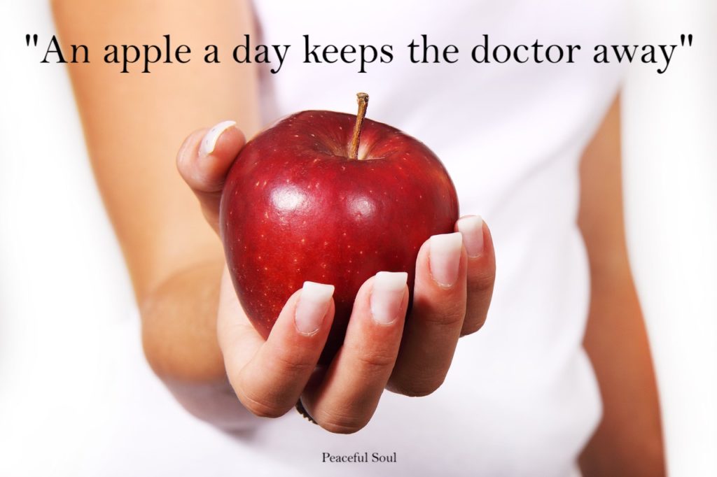 Woman holding an apple; Quote: "An apple a day keeps the doctor away" - quotes about healthy eating
