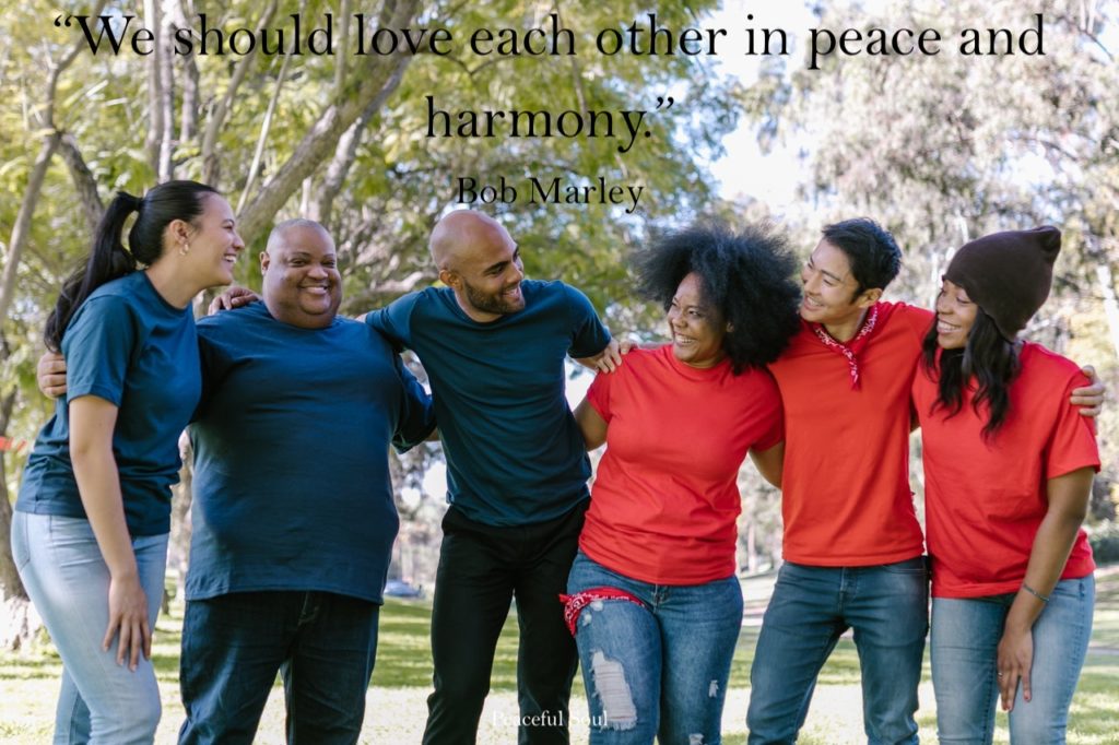 Group of people hugging and smiling - “We should love each other in peace and harmony.” Bob Marley - Love for others quotes - quotes about love