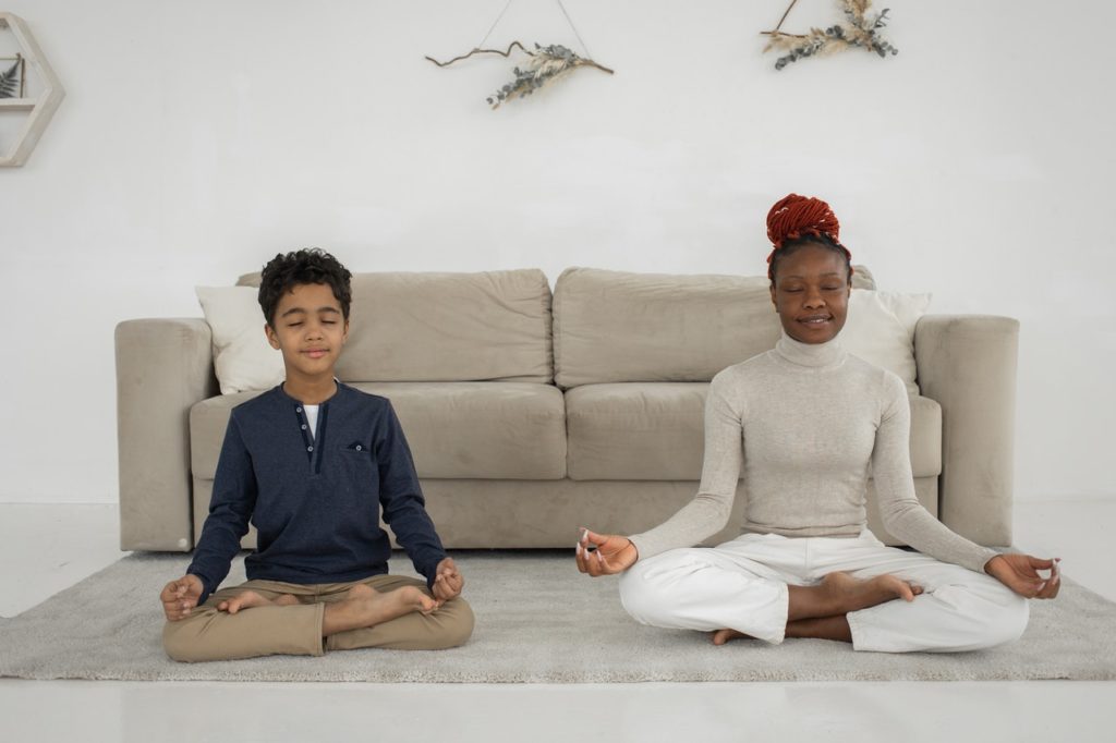 Two young people meditating and smiling - Benefits of meditation and mindfulness