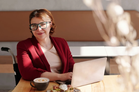 Woman sat in a wheelchair with a laptop next on the table next to her. Introduction to An Entrepreneurial Guide for Parents With Disabilities